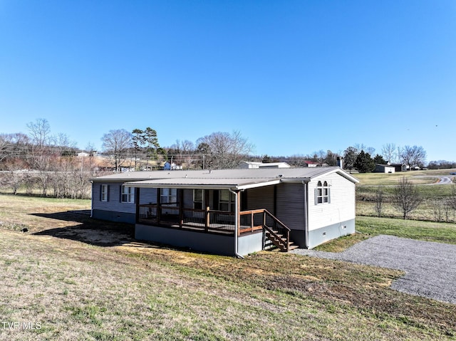 rear view of house with metal roof, a lawn, and crawl space