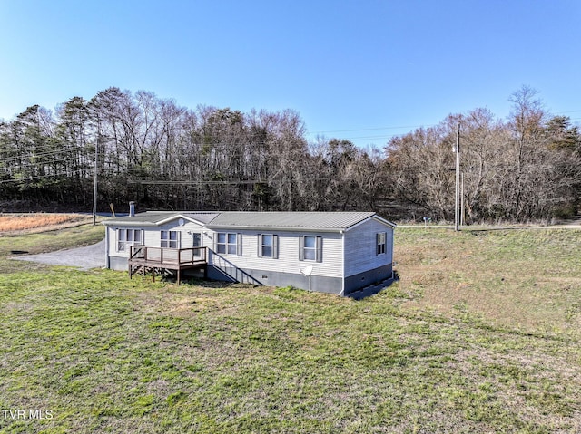 manufactured / mobile home featuring crawl space, metal roof, a deck, and a front yard