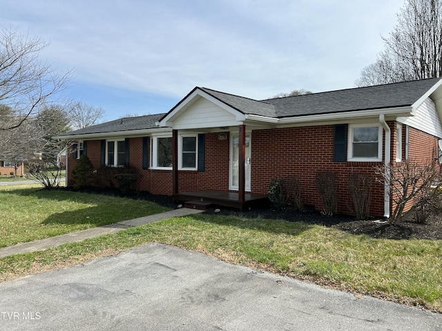 view of front of house featuring brick siding and a front yard