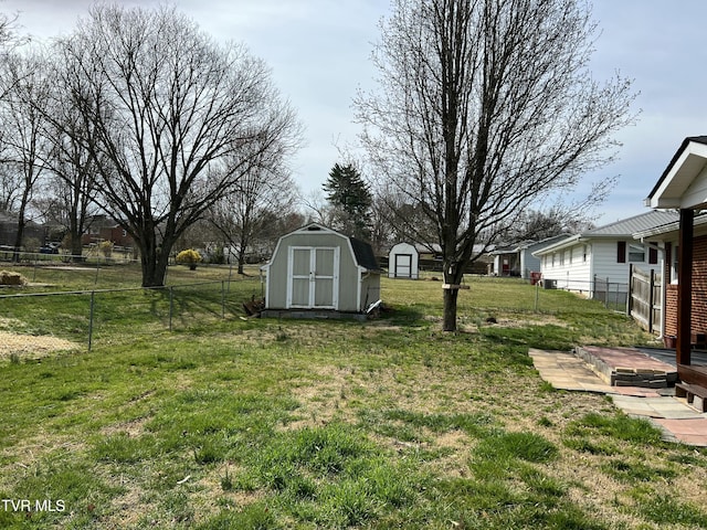 view of yard featuring an outdoor structure, a fenced backyard, and a shed