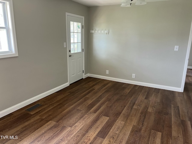 interior space with dark wood-type flooring, baseboards, visible vents, and a chandelier