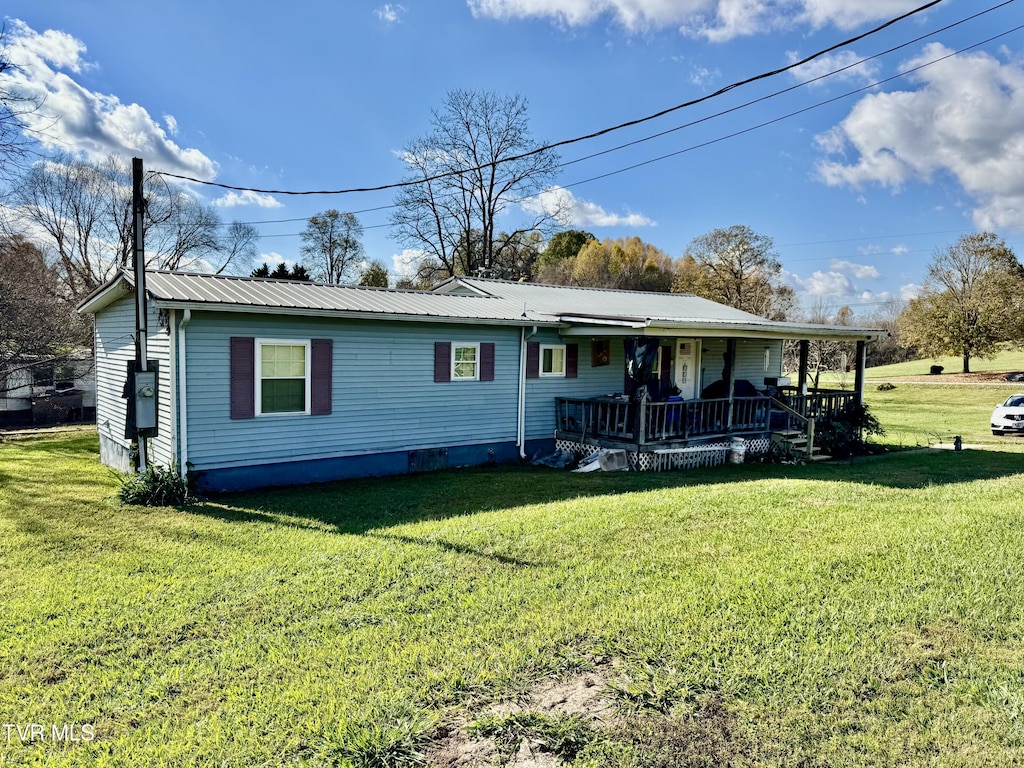 back of property featuring metal roof, a yard, and a porch