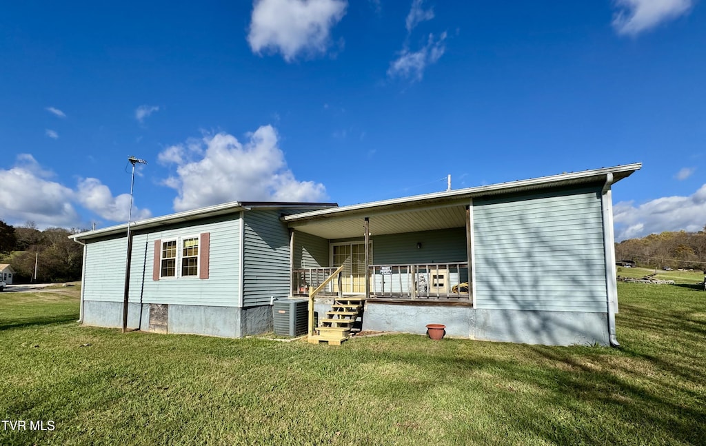 back of property with a porch, a yard, and central AC unit