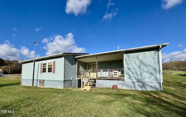 back of property with a porch, a yard, and central AC unit