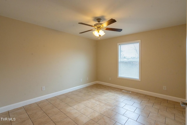 spare room featuring a ceiling fan, visible vents, and baseboards