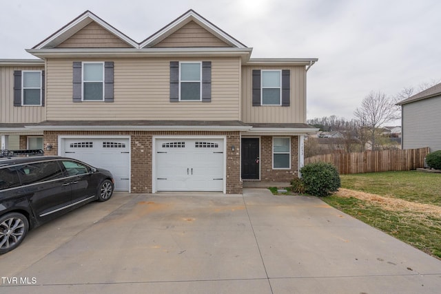 view of front of home with brick siding, concrete driveway, a garage, and fence