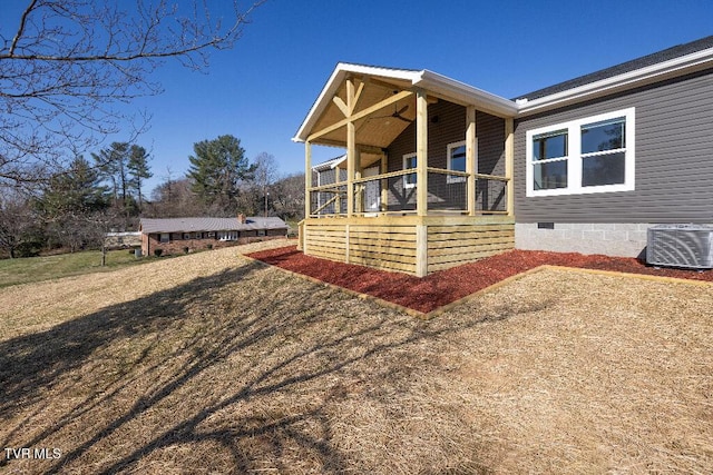 rear view of property with central air condition unit, covered porch, a yard, crawl space, and a ceiling fan