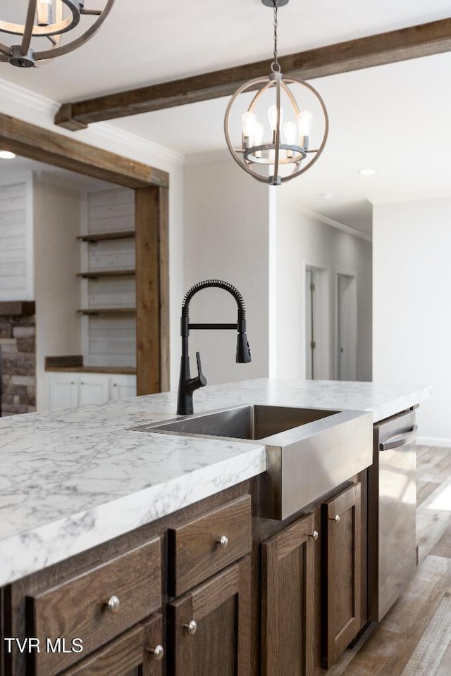 kitchen featuring beamed ceiling, ornamental molding, stainless steel dishwasher, an inviting chandelier, and a sink