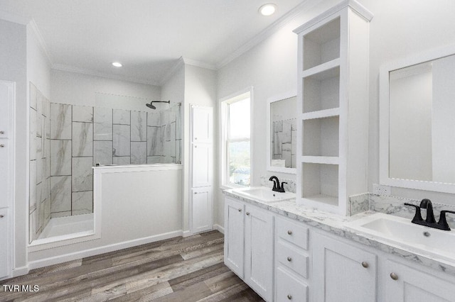 bathroom with ornamental molding, wood finished floors, walk in shower, and a sink