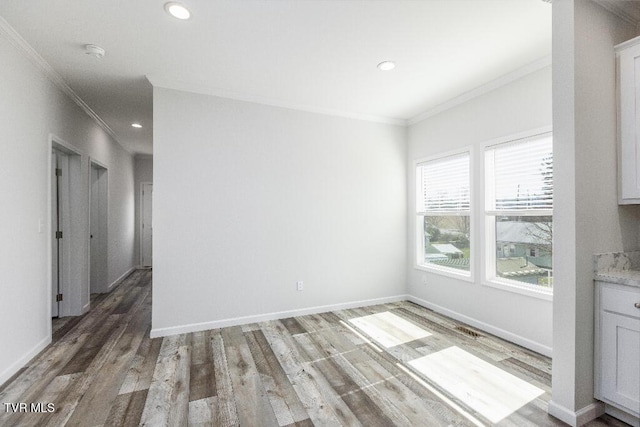 unfurnished dining area with crown molding, light wood-style floors, and baseboards