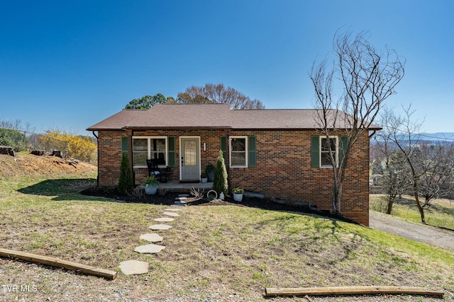 ranch-style house with brick siding, a porch, and a front yard