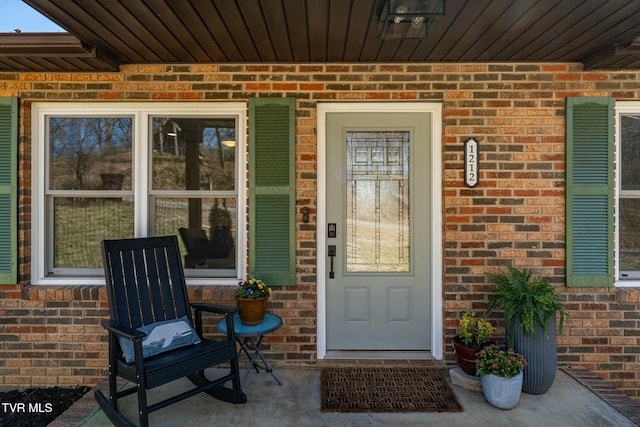 doorway to property with brick siding