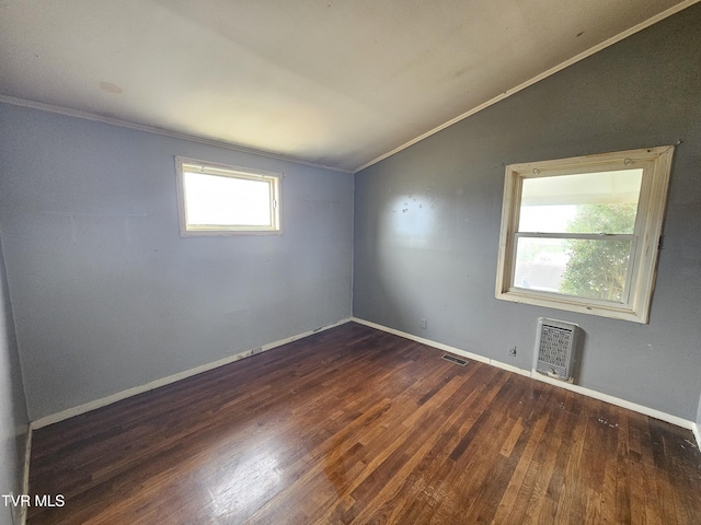 spare room featuring lofted ceiling, crown molding, wood finished floors, and visible vents