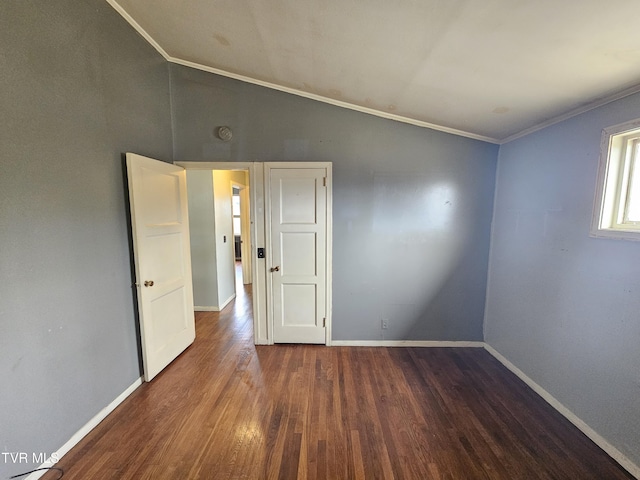 spare room with ornamental molding, baseboards, lofted ceiling, and wood finished floors