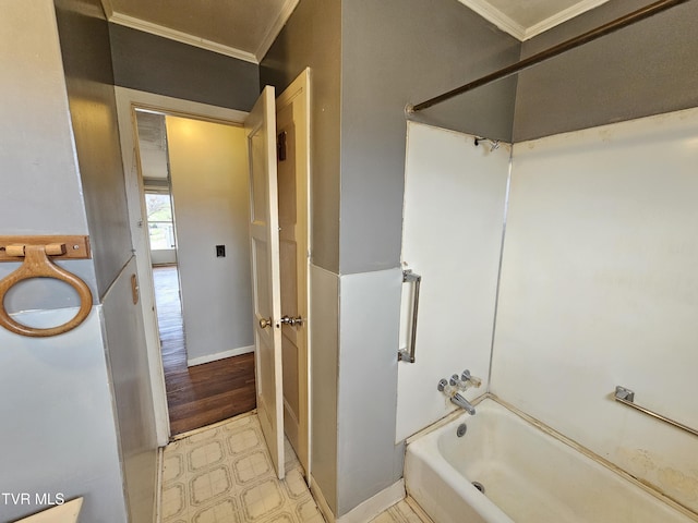 bathroom featuring tub / shower combination, baseboards, and ornamental molding