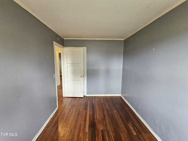 empty room featuring baseboards, wood finished floors, and ornamental molding