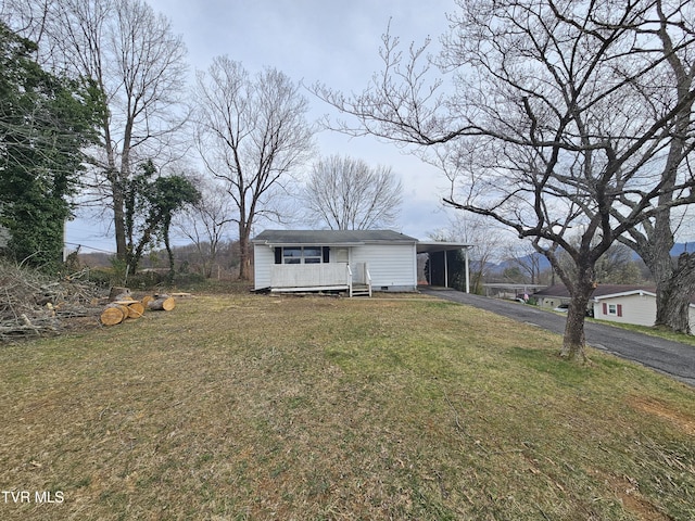 view of front of home with a carport, driveway, and a front lawn