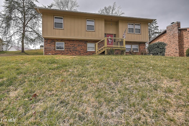 raised ranch featuring brick siding, board and batten siding, and a front lawn