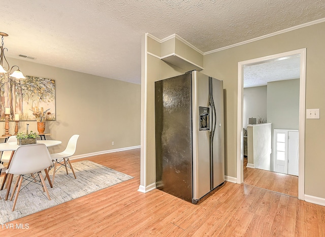 kitchen with visible vents, a textured ceiling, wood finished floors, stainless steel fridge with ice dispenser, and a chandelier