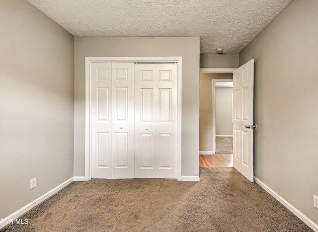unfurnished bedroom with a closet, carpet floors, and baseboards