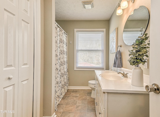 full bath with visible vents, baseboards, toilet, vanity, and a textured ceiling