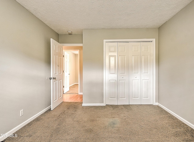 unfurnished bedroom with baseboards, carpet, and a textured ceiling