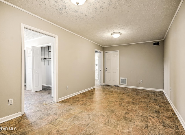 empty room with visible vents, crown molding, and baseboards