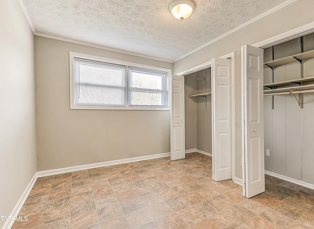unfurnished bedroom with baseboards, two closets, and a textured ceiling