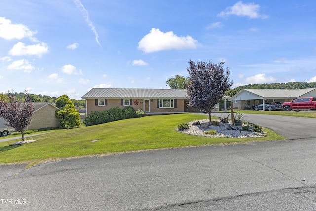 ranch-style home featuring an attached carport, driveway, brick siding, and a front yard