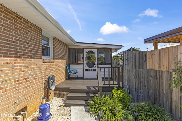 deck with fence and a sunroom