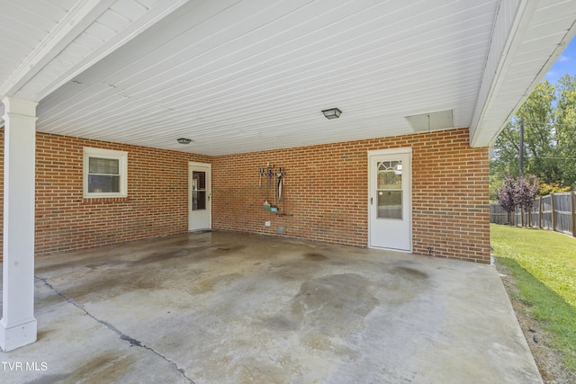 view of patio featuring an attached carport and fence