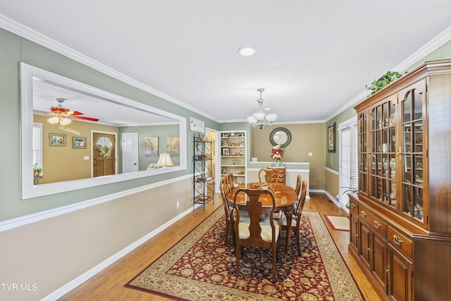 dining space with light wood-style flooring, crown molding, and baseboards