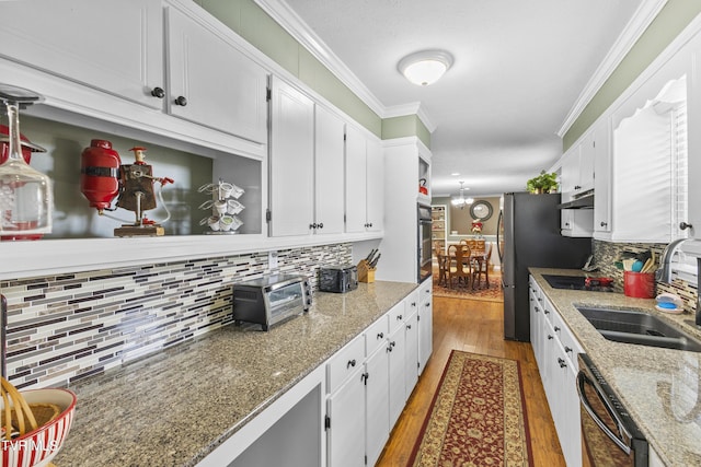 kitchen with ornamental molding, dishwasher, white cabinetry, and a sink