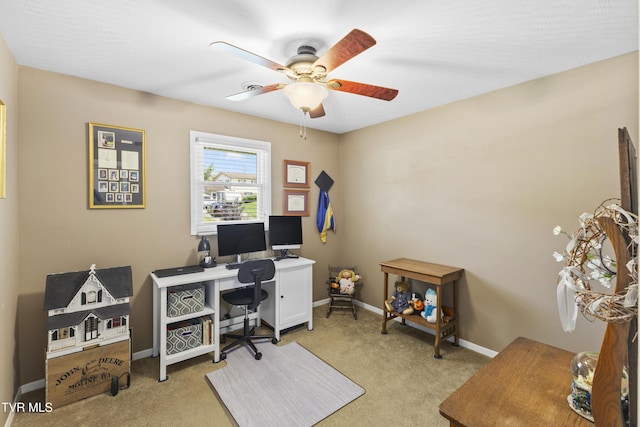 office space featuring baseboards, light carpet, and ceiling fan