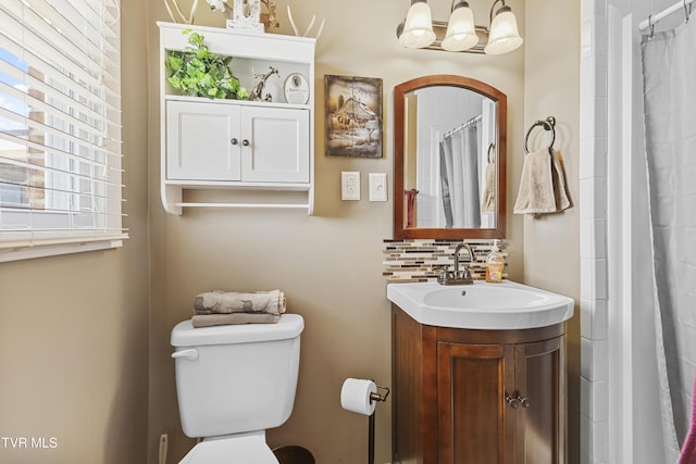 bathroom featuring backsplash, toilet, a shower with shower curtain, a notable chandelier, and vanity