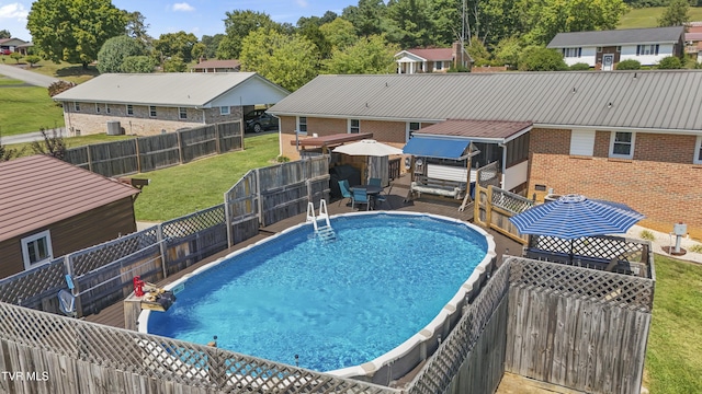 view of swimming pool with a residential view, a lawn, a fenced backyard, and a fenced in pool