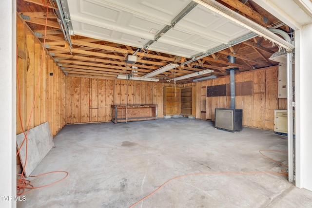 garage featuring wood walls and a wood stove