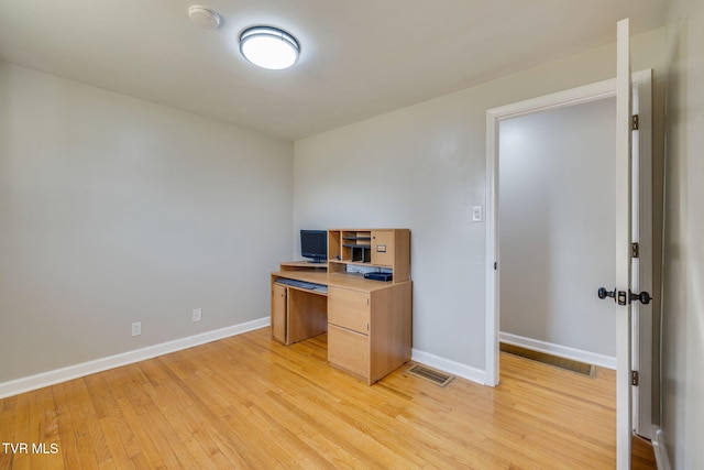 unfurnished office with light wood-style floors, visible vents, and baseboards