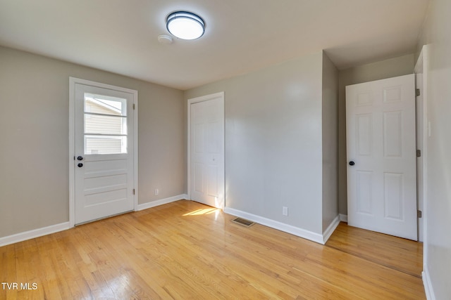 interior space featuring visible vents, light wood-style flooring, and baseboards