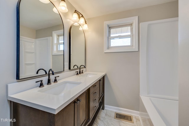 full bath with baseboards, visible vents, marble finish floor, and a sink