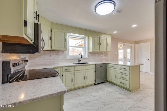 kitchen with a peninsula, a sink, stainless steel appliances, marble finish floor, and backsplash