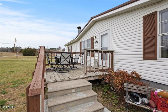 wooden deck featuring outdoor dining space and a lawn