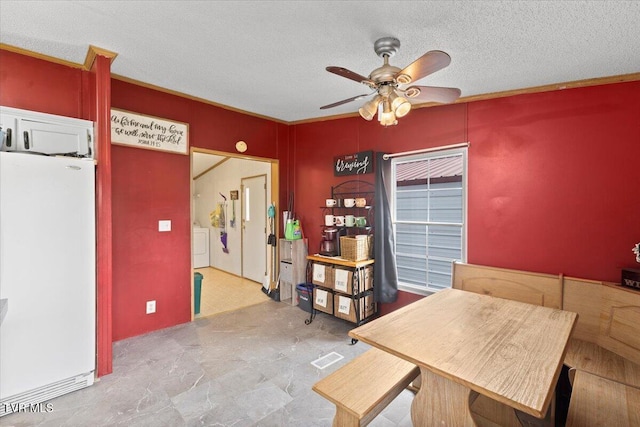 unfurnished dining area featuring a ceiling fan, separate washer and dryer, visible vents, and a textured ceiling