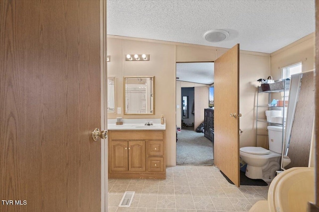 bathroom with visible vents, a textured ceiling, vanity, and toilet