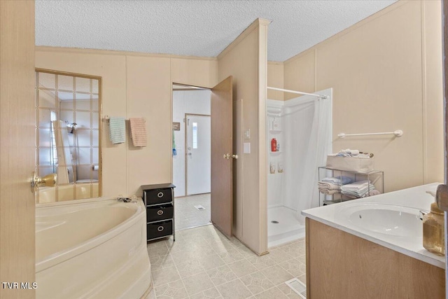 bathroom with a textured ceiling, a shower stall, a bath, and a sink