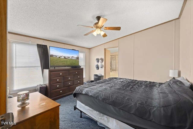 carpeted bedroom with ceiling fan, crown molding, and a textured ceiling