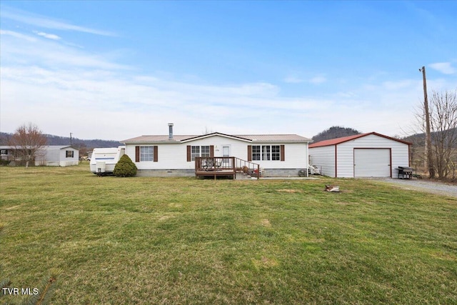 manufactured / mobile home with an outbuilding, a front lawn, driveway, a detached garage, and crawl space