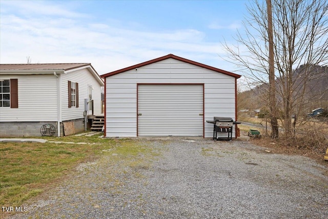 detached garage featuring gravel driveway