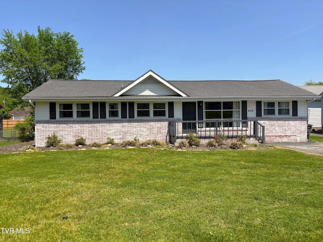 ranch-style home with brick siding, a front lawn, and covered porch