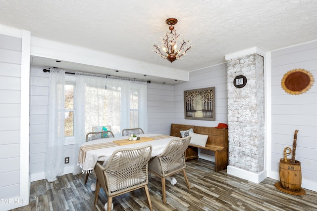 dining room featuring wood finished floors, baseboards, a chandelier, and a textured ceiling